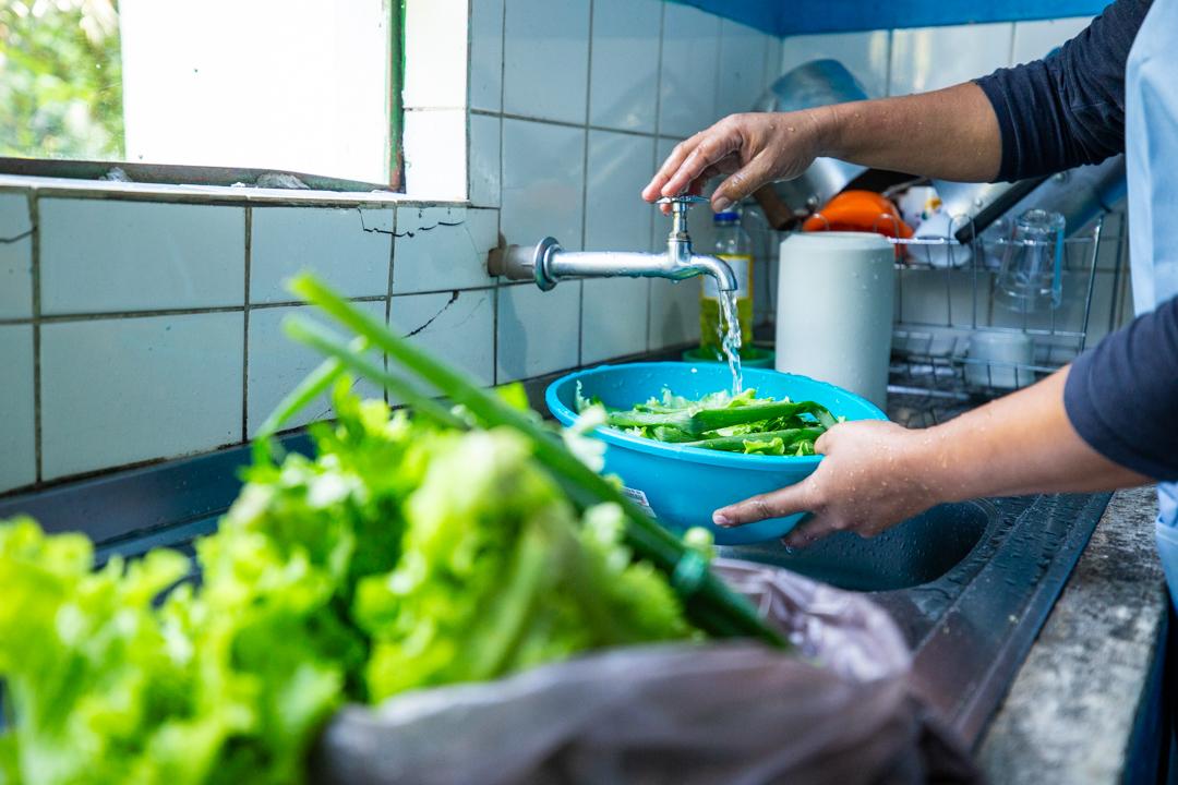 A merendeira Regianí Afonso separa os alimentos recebidos dos agricultores quilombolas e prepara a merenda do dia, com o acompanhamento da nutricionista Mariana Camargo | Fellipe Abreu/ISA