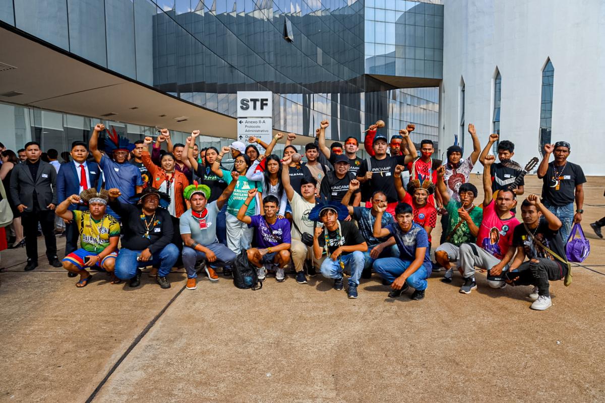 Participantes da Apib durante a audiência de retirada da comissão do marco temporal. Na foto, os indígenas posam com os braços levantados em sinal de força e resistência