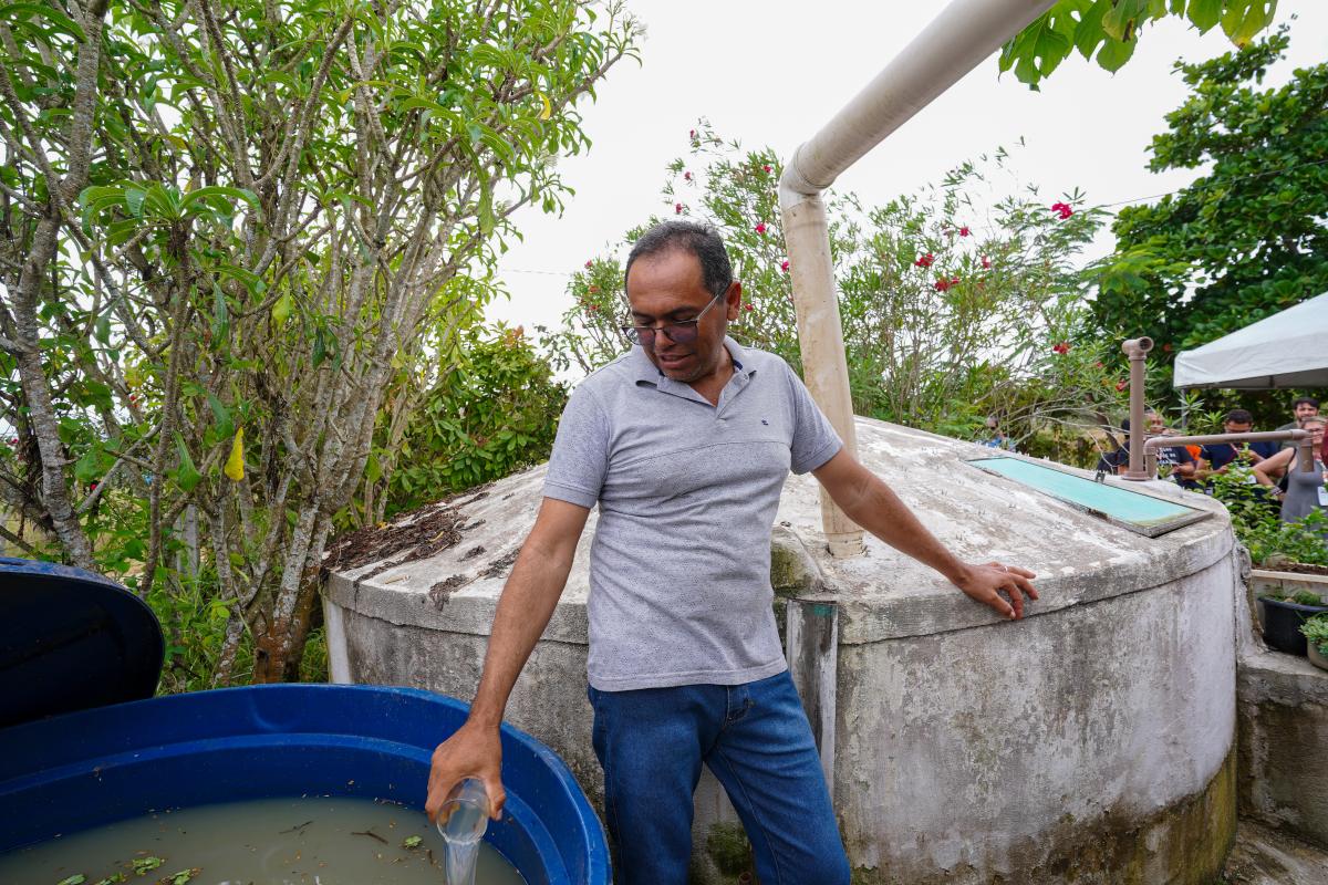 Homem mostra sua cisterna, no quintal de casa