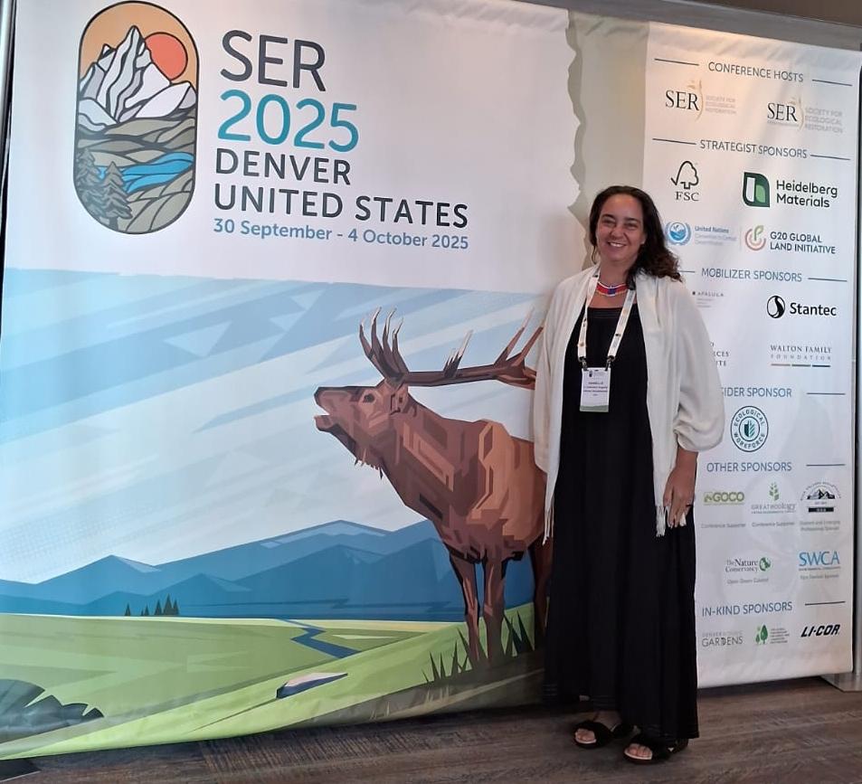 Danielle Celentano, analista de Restauração Ecológica do ISA pousa em frente ao painel do SER 2025
